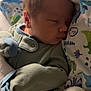 baby, sleeping, newborn, infant, blanket, clothing, pajamas, bed, soft, cute, face, child, resting, cozy, warm, indoors, portrait, peaceful, dinosaur_print, closeup