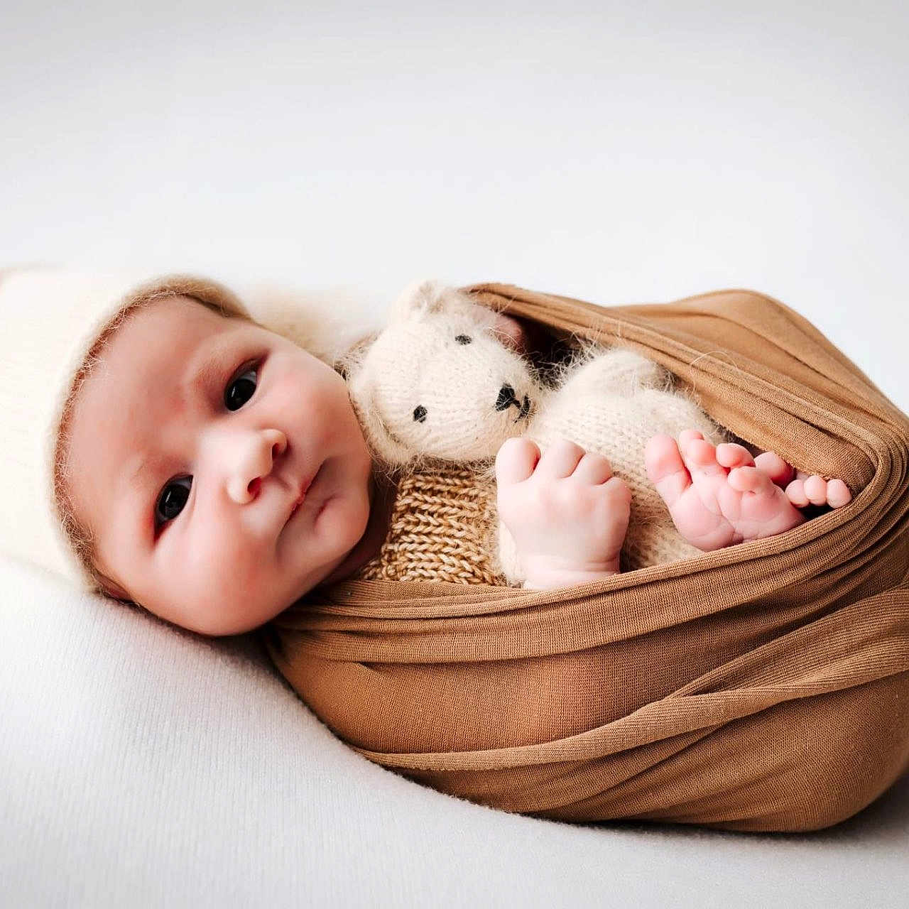 Ezio a rejoint le concours — aidez-le/la à gagner de superbes lots ! baby, baby_hands, child, closeup, cozy, cute, infant, knit_hat, laying_down, newborn, peaceful, portrait, sleepy, small_feet, soft_texture, soft_toy, swaddle, teddy_bear, white_background, wrapped