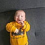 Jarod participe au concours pour gagner de l'argent avec cette photo : baby, infant, smiling, happy, yellow_sweater, sweatshirt, car_print, couch, sofa, indoor, portrait, cute, hands, face, head, chubby_cheeks, clothing, relaxed, cozy, lying_down