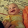 Jarod participe au concours pour gagner de l'argent avec cette photo : baby, infant, smiling, smile, face, hand, adult_hand, bed, blanket, bedding, onesie, animal_print, orange_blanket, cozy, portrait, close_up, cheerful, pattern, nursery, cute