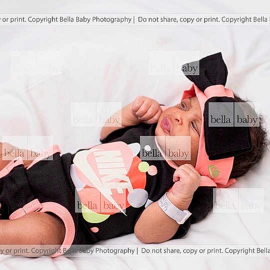 Anyla is registered to the contest to win money with this photo: baby, infant, clothing, nike, headband, bow, pink, black, white_background, lying_down, newborn, wristband, cute, portrait, child, smiling, indoors, babywear, fabric, resting