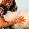 Balto a rejoint le concours — aidez-le/la à gagner de superbes lots ! affection, animal, bracelet, close_up, colorful_clothing, dog, fluffy_dog, golden_hour, grass, hand, happy, long_hair, nature, outdoor, pet, portrait, smiling, sunlight, tattoo, woman