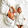 baby, adult, bathrobe, bed, blanket, bonding, child, comfort, family, holding_hands, indoor, mother, person, portrait, relaxation, towel, towel_wrap, white, lying_down, skin