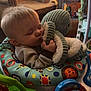 Alexander is registered to the contest to win money with this photo: baby, sleeping, plush_toy, activity_center, indoor, child, toy, furniture, couch, blanket, peaceful, cute, infant, colorful, playful, home, comfort, soft, resting, toddler
