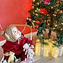 Teo is registered to the contest to win money with this photo: baby, chair, child, christmas_tree, crocheted_toys, cute, festive, flooring, gift_boxes, holiday_decor, holiday_season, indoors, knitted_hat, portrait, red_wall, soft_lighting, stuffed_animals, toddler, twinkling_lights, winter_clothing