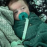 baby, pacifier, blanket, stars, moon, swaddle, sleepy, face, infant, cozy, soft_texture, blue_eyes, child, portrait, indoor, cute, wrapped, calm, resting, fabric