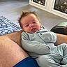 Atticus joined the competition — help win amazing prizes! baby, infant, person, child, spiky_hair, tongue_out, onesie, arm, human_skin, couch, rug, floor, cabinet, pet_cage, dog, home_interior, furniture, legs, comfort, relaxation