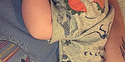 Ridge joined the competition — help win amazing prizes! baby, infant, child, onesie, dinosaur_print, sleepy, person, hand, tattoo, clothing, holding, closeup, cute, skin, face, arm, casual, indoor, resting, toddler