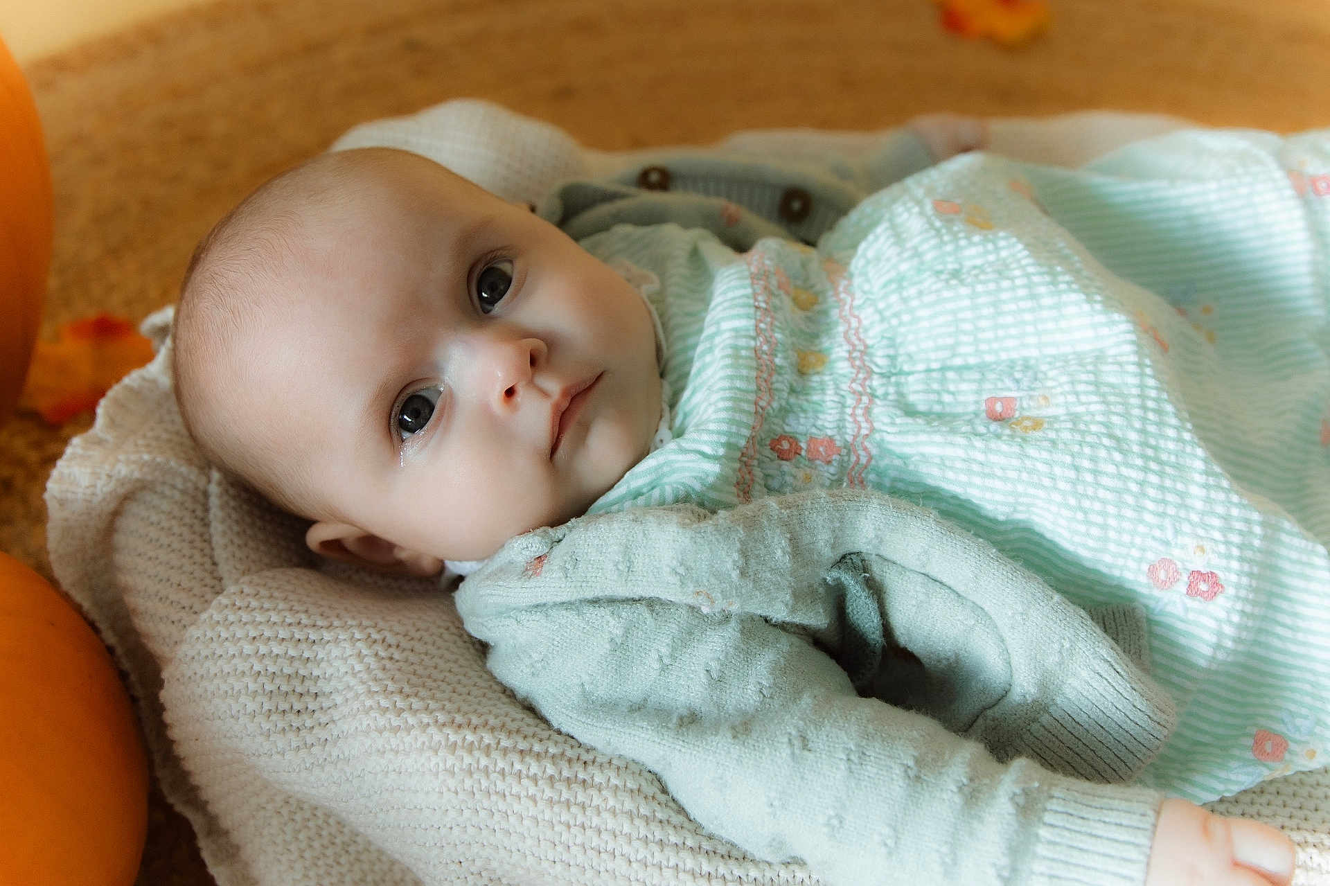 Blair joined the competition — help win amazing prizes! baby, infant, blanket, knit, green_clothing, pastel, face, portrait, indoors, pumpkin, autumn, soft_lighting, closeup, cute, child, young, peaceful, laying_down, warm_colors, cozy