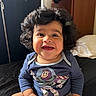 Luca joined the competition — help win amazing prizes! baby, bed, blue_onesie, buzz_lightyear, child, curly_hair, cute, diaper, face, furniture, happy, head, indoor, infant, person, portrait, room, sitting, smiling, toy