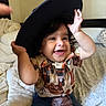 Luca joined the competition — help win amazing prizes! bed, blanket, child, clothing, curly_hair, cute, face, hands, happy, hat, indoor, jeans, person, pillow, playful, portrait, shirt, smiling, toddler, young_child