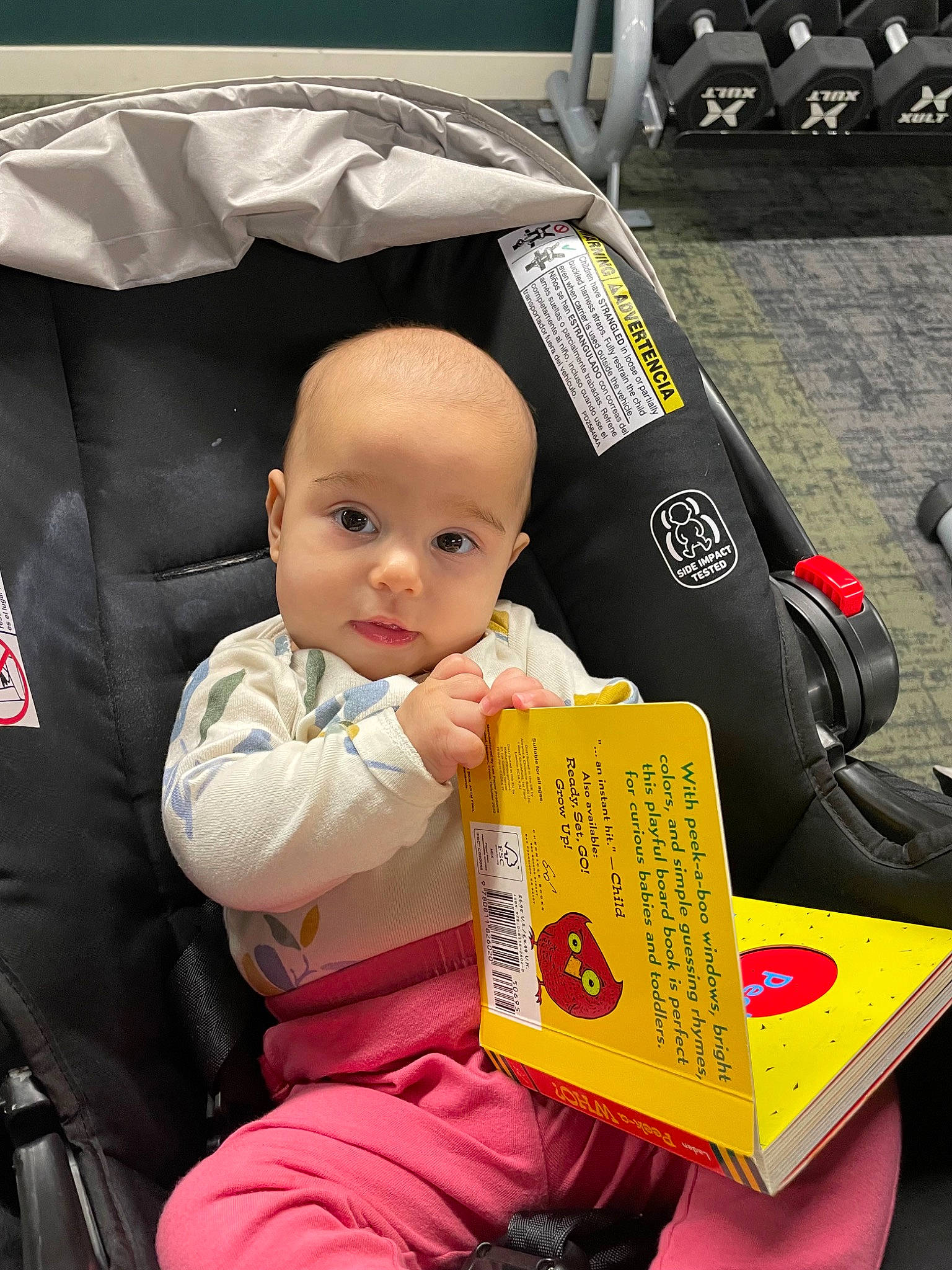 Noelle is registered to the contest to win money with this photo: baby, baby_carriage, baby_products, baby_toddler_clothing, bag, car_seat, child, lap, motor_vehicle, person, sitting, toddler, toy, transport, travel, vehicle, wheel