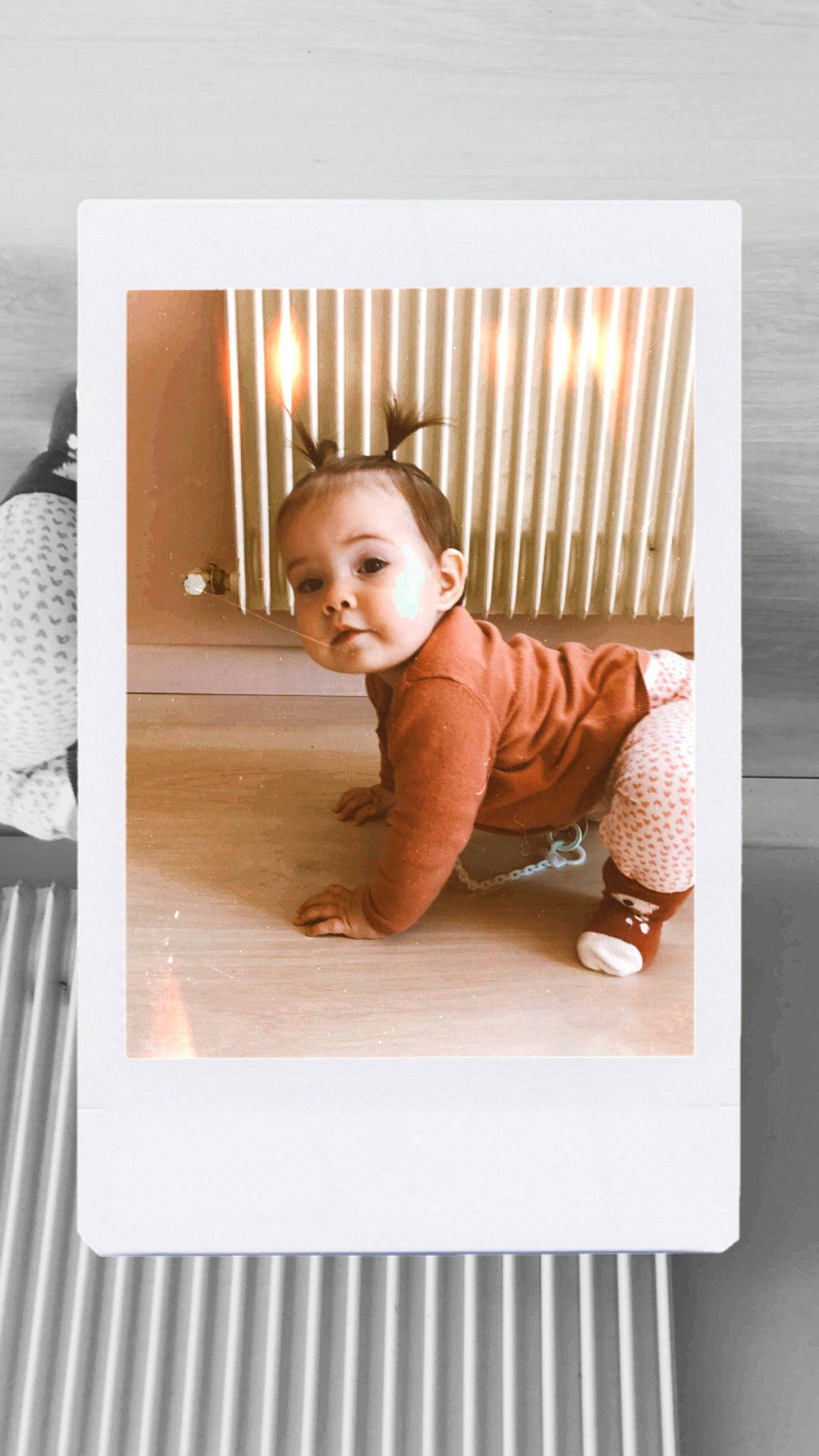 Théodora a rejoint le concours — aidez-le/la à gagner de superbes lots ! art, baby, baby_toddler_clothing, child, comfort, flooring, hardwood, person, photographic_paper, portrait_photography, product, rectangle, room, sitting, sleeve, smile, t_shirt, toddler, wood