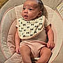 baby, infant, bib, baby_seat, clothing, pink_shorts, face, skin, legs, feet, hand, cushion, comfort, indoor, child, cute, young, expression, portrait, small