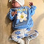 baby, sleeping, blue_clothing, headwrap, daisy, flower_pattern, socks, infant, soft_texture, blanket, cute, peaceful, child, portrait, laying_down, small_hands, newborn, cozy, comfortable, resting