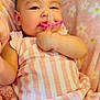 baby, infant, pacifier, pink, striped_clothing, blanket, floral_pattern, cute, child, sleeping_area, soft_texture, closeup, indoor, person, skin, hand, face, head, comfort, resting