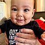 baby, black_shirt, child, closeup, clothing, cute, expression, eyes, face, hand, holding, human, indoor, infant, people, person, portrait, skin, smile, young_child