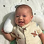 Ashton is registered to the contest to win money with this photo: baby, smiling, infant, onesie, airplane_pattern, cushion, bear_shape, soft_toy, cute, happy, child, portrait, lying_down, indoors, closeup, face, head, baby_clothing, fabric, comfort