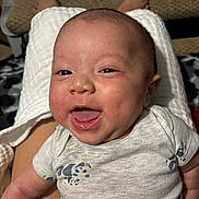 Ashton joined the competition — help win amazing prizes! baby, infant, smiling, face, person, clothing, panda_print, onesie, happy, skin, head, eyes, mouth, tongue, legs, feet, blanket, texture, indoor, closeup