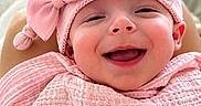 Aurora Elowen is registered to the contest to win money with this photo: baby, blanket, bow, child, closeup, cozy, cute, expression, face, happy, headwear, indoors, infant, person, pink_blanket, pink_hat, portrait, smiling, soft_texture, wrapped