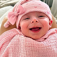 Aurora Elowen is registered to the contest to win money with this photo: baby, pink, hat, bow, blanket, smiling, face, happy, cute, infant, child, clothing, portrait, indoors, soft_texture, headwear, person, closeup, warm, cozy