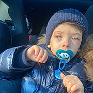 Kassim Menassel participe au concours pour gagner de l'argent avec cette photo : baby, blue_jacket, car_interior, child, closeup, curious, face, hand, indoor, knit_hat, pacifier, person, portrait, seat, seatbelt, sunlight, toddler, warm_clothing, winter_clothing, young_child