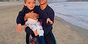 Isaak a rejoint le concours — aidez-le/la à gagner de superbes lots ! beach, casual_clothing, child, clouds, coast, footwear, holding, nature, outdoor, people, portrait, sand, sea, shore, sky, sporty_clothing, sunset, teenager, toddler, water