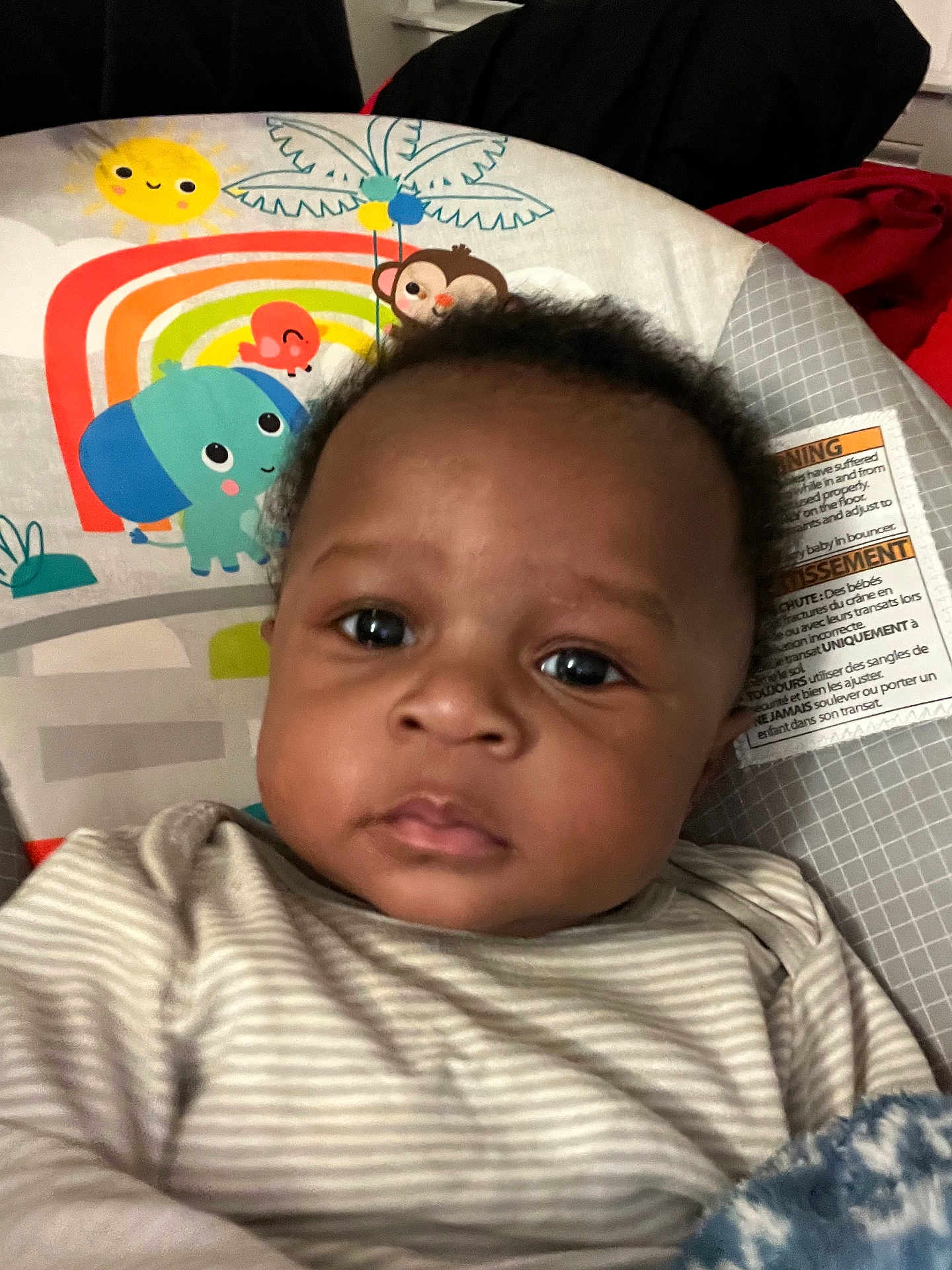 Nyairre is registered to the contest to win money with this photo: baby, child, face, infant, striped_clothing, blanket, baby_seat, cartoon_animals, indoor, closeup, portrait, young_child, cute, expression, furniture, comfort, soft_toys, head, person, seat