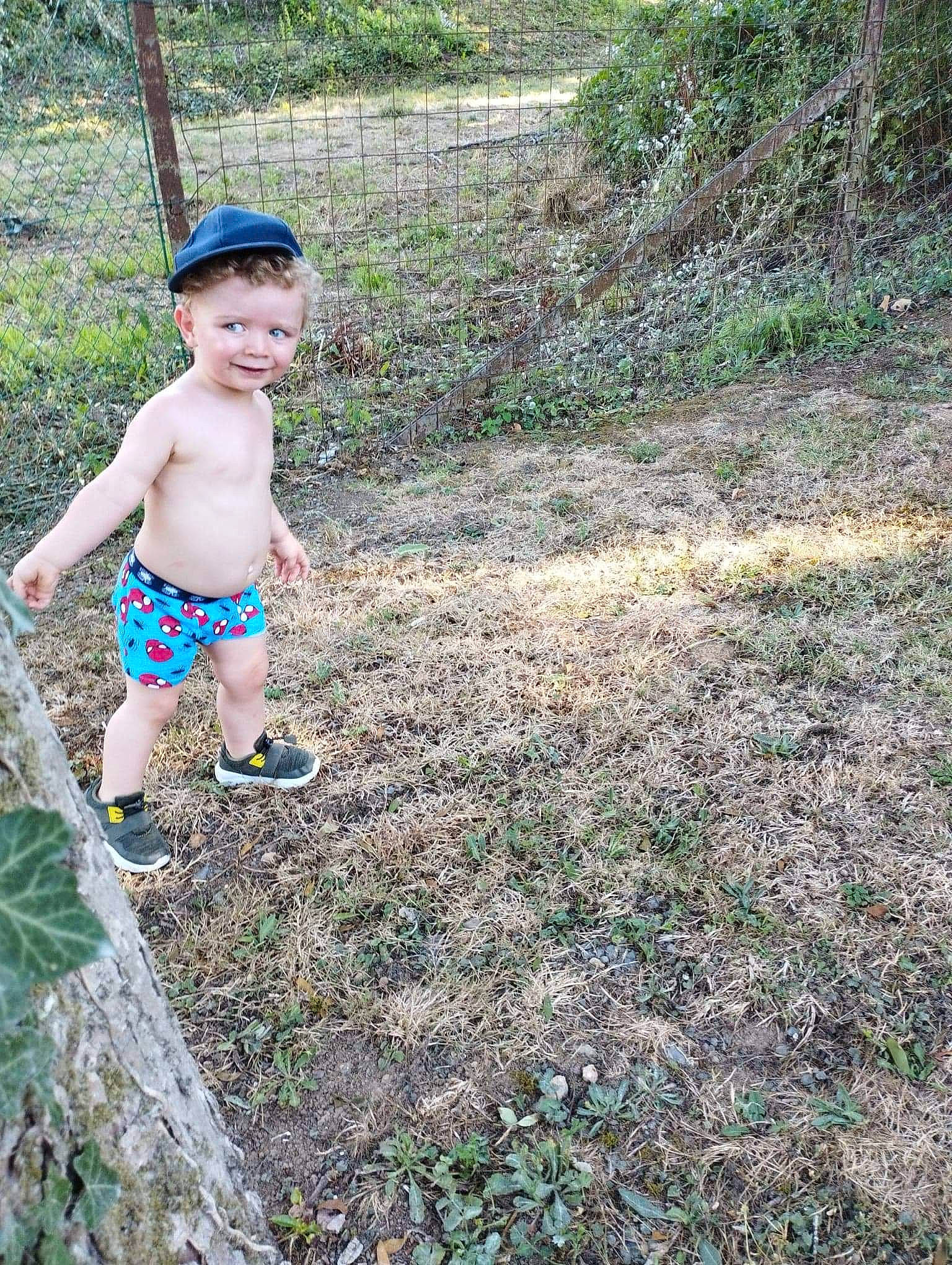 Tiago participe au concours pour gagner de l'argent avec cette photo : baby, barechested, forest, grass, groundcover, happy, joy, jungle, landscape, leisure, people_in_nature, person, plant, recreation, rock, shorts, smile, soil, toddler, tree