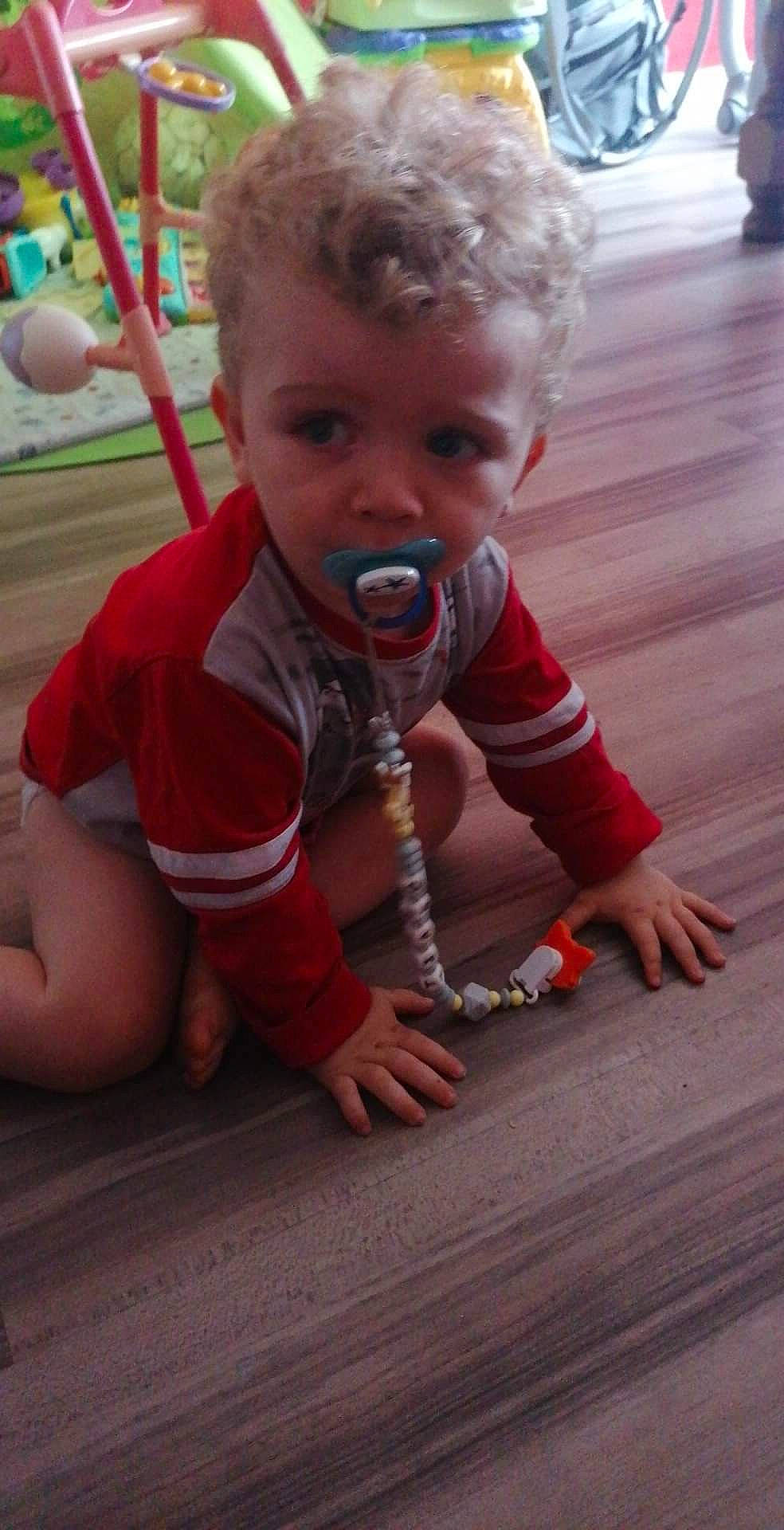 Tiago a rejoint le concours — aidez-le/la à gagner de superbes lots ! baby, baby_toddler_clothing, balloon, child, finger, flooring, fun, grass, happy, hardwood, leisure, nose, pattern, person, recreation, sitting, skin, smile, thumb, toddler