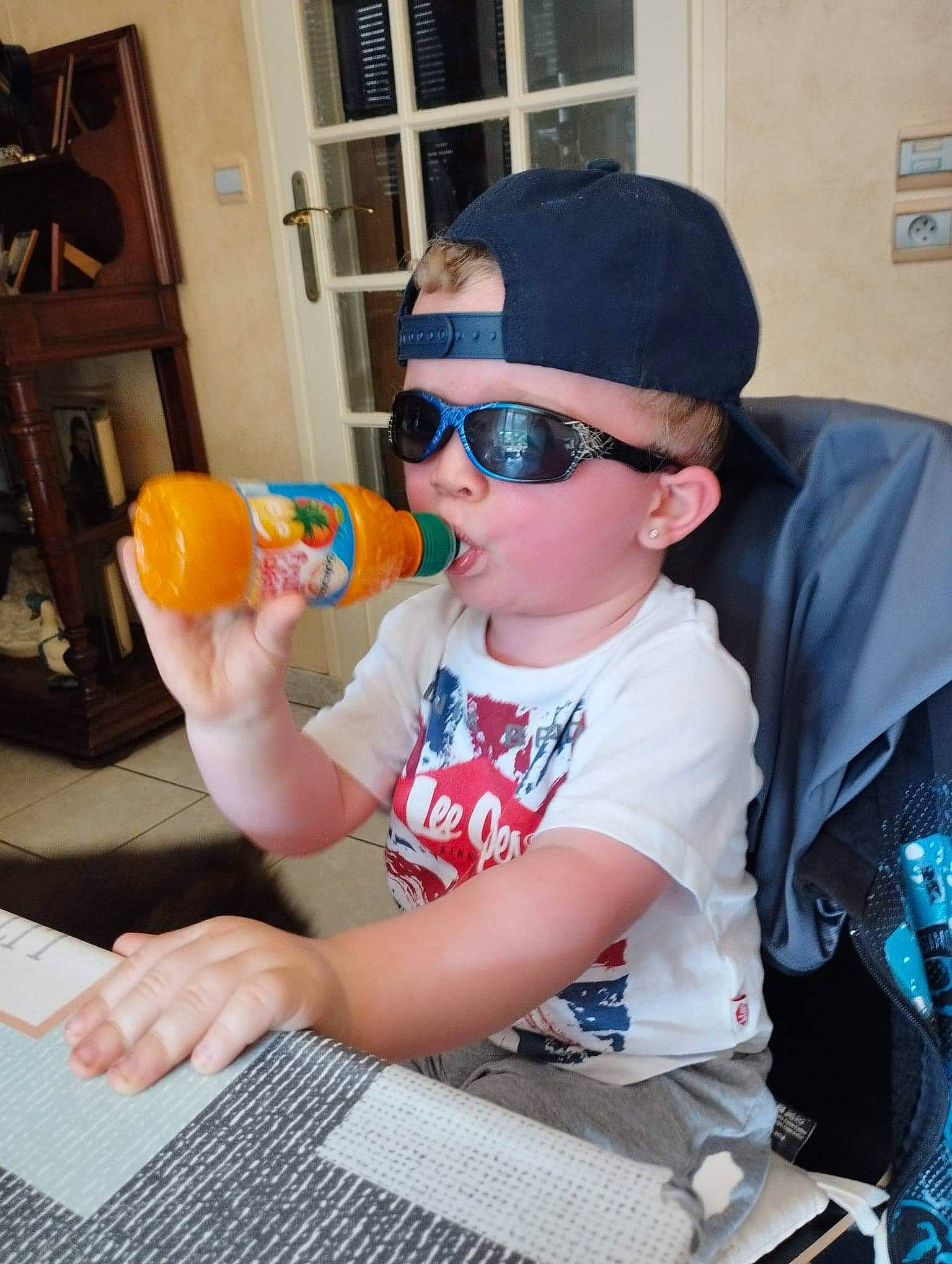Tiago participe au concours pour gagner de l'argent avec cette photo : baseball_cap, cap, child, costume_hat, event, eyewear, fashion_accessory, fruit, fun, glasses, goggles, hat, headwear, leisure, person, personal_protective_equipment, recreation, sitting, sunglasses, tableware