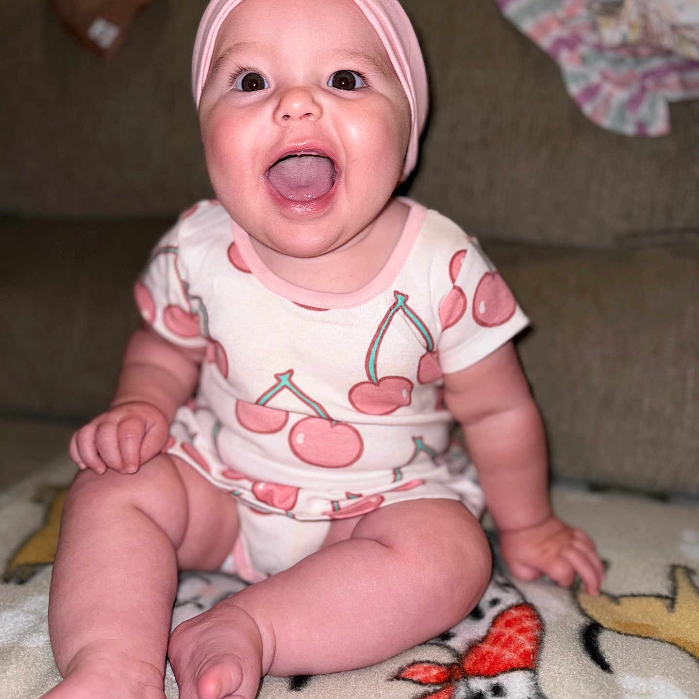 Riley is registered to the contest to win money with this photo: baby, babylaughing, bodypart, clothing, couch, cushion, face, finger, furniture, hand, happy, hat, head, homedecor, laughing, person, photography, portrait, sitting, t_shirt