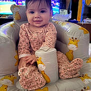 Charlie joined the competition — help win amazing prizes! baby, infant, child, smiling, giraffe_print, inflatable_seat, pink_onesie, floral_pattern, living_room, television, audience, toy, blanket, hands, face, hair, cozy, sitting, portrait, cute