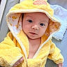 baby, baby_bathrobe, blanket, child, cozy, cute, duck_design, expression, eyes, face, hand, hooded_towel, indoors, infant, person, portrait, skin, soft_texture, warm_clothing, yellow_bathrobe
