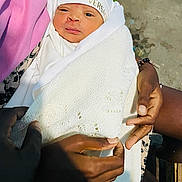 Gil Júnior participe au concours pour gagner de l'argent avec cette photo : newborn, baby, infant, wrapped, blanket, hands, white_clothing, hat, versace, person, indoor, skin, face, expression, knit, holding, warmth, curious, portrait, care