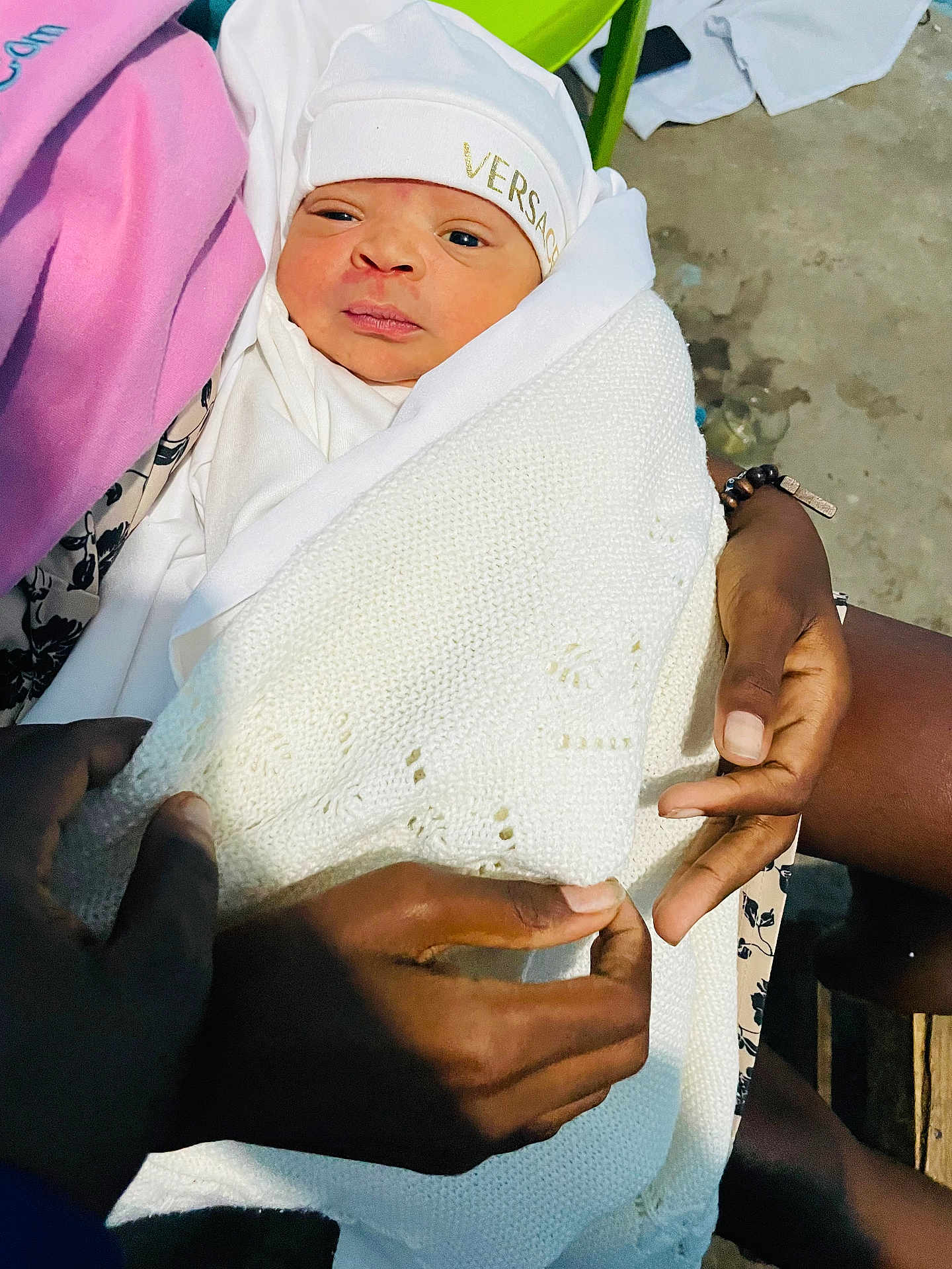 Gil Júnior participe au concours pour gagner de l'argent avec cette photo : newborn, baby, infant, wrapped, blanket, hands, white_clothing, hat, versace, person, indoor, skin, face, expression, knit, holding, warmth, curious, portrait, care