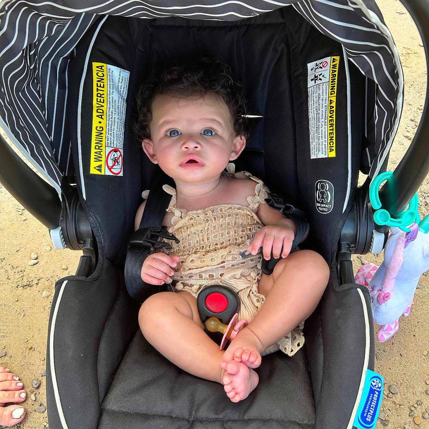 Eriyah joined the competition — help win amazing prizes! baby, black_car_seat, blue_eyes, car_seat, child, curly_hair, cute, daylight, foot, infant, outdoor, pacifier, plush_toy, sand, seated, skin, straps, summer, toy, warning_label