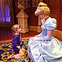 child, girl, princess, cinderella, costume, dress, blue, carpet, indoor, kneeling, smiling, curtain, vase, decor, wood_paneling, interaction, happy, portrait, fantasy, character