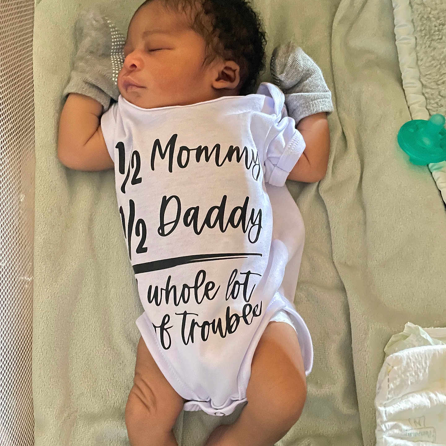 Kamarion Gaskill is registered to the contest to win money with this photo: baby, newborn, sleeping, onesie, clothing, mittens, pacifier, blanket, diaper, infant, cute, peaceful, lying_down, soft_texture, indoors, child, adorable, toddler, face, human