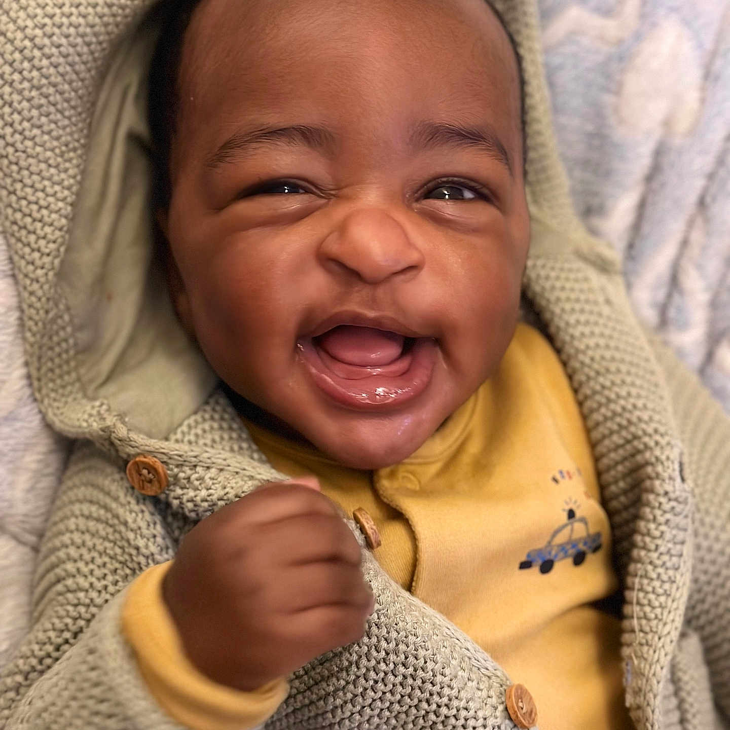 Liam is registered to the contest to win money with this photo: baby, babylaughing, bodypart, clothing, coat, face, finger, happy, head, hood, hoodie, jacket, knitwear, laughing, person, photography, portrait, smile, sweater, sweatshirt