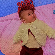 Millie joined the competition — help win amazing prizes! baby, infant, knitwear, blanket, pink_blanket, blue_mat, headband, 2026, cute, lying_down, clothing, warm_clothes, face, expression, indoors, soft_texture, child, new_year, celebration, portrait