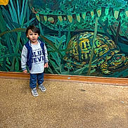Elias joined the competition — help win amazing prizes! child, boy, mural, painting, turtle, floor, wall, indoor, curious, standing, casual_clothing, sneakers, short_hair, artwork, green, blue, yellow, nature_theme, person, portrait