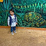 child, boy, mural, painting, turtle, floor, wall, indoor, curious, standing, casual_clothing, sneakers, short_hair, artwork, green, blue, yellow, nature_theme, person, portrait
