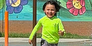 Elias joined the competition — help win amazing prizes! child, running, splash_pad, water, green_shoes, neon_shirt, shorts, smiling, outdoor, mural, wall_painting, flowers, cats, playground, summer, fun, happy, motion, water_splash, daytime