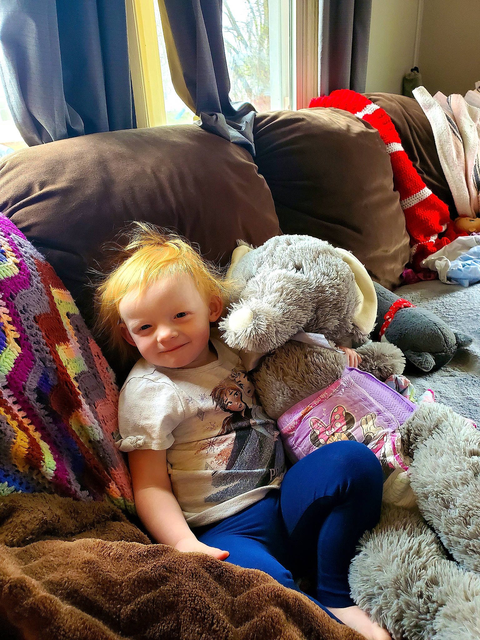 Amira is registered to the contest to win money with this photo: blond, child, comfort, couch, curtain, event, fun, hairstyle, happy, human, interaction, joy, lap, living_room, mammal, morning, people, person, sitting, smile