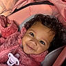 baby, child, closeup, comfort, cozy, curly_hair, cute, face, happy, indoor, infant, pacifier, person, pink_jacket, portrait, smile, soft_texture, stroller, warm_clothing, young_child