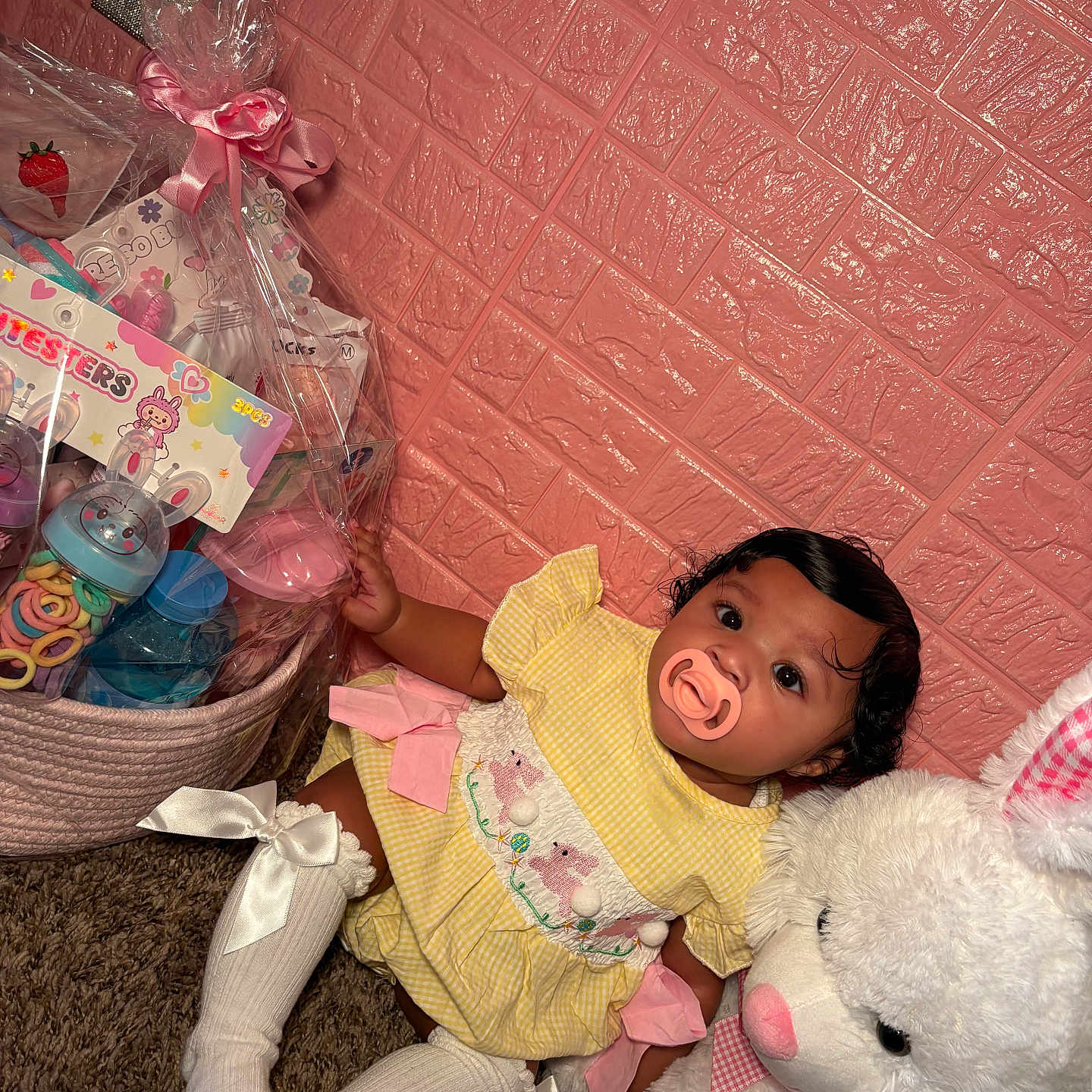 Azurii is registered to the contest to win money with this photo: baby, basket, bunny, carpet, child, cute, decor, floor, gift_wrap, indoors, infant, pacifier, person, pink_wall, plush_toy, portrait, ribbon, toys, white_socks, yellow_dress