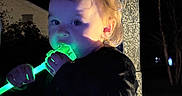 Journey joined the competition — help win amazing prizes! toddler, child, adult_hand, night, glowing_object, green_light, face, person, dark_background, stone_pillar, outdoor, curly_hair, holding, illumination, portrait, cute, baby, hand, shadow, glow