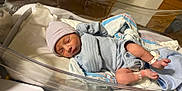 Jaylen is registered to the contest to win money with this photo: newborn, baby, infant, sleeping, hospital, bassinet, blanket, hat, clothing, person, medical, ward, foot, hand, bed, quiet, resting, hospital_room, patient, cute