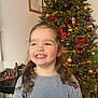 Maëlle participe au concours pour gagner de l'argent avec cette photo : child, girl, smile, curly_hair, christmas_tree, holiday, decorations, ornaments, lights, indoor, festive, happy, portrait, celebration, young, person, long_sleeve, gray_shirt, home, seasonal